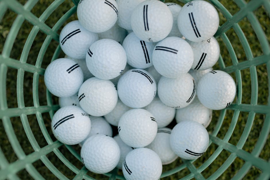 A high-angle view of golf balls in a basket on grass, illustrating golfing equipment.